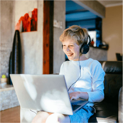 Kid laughing in front of a laptop